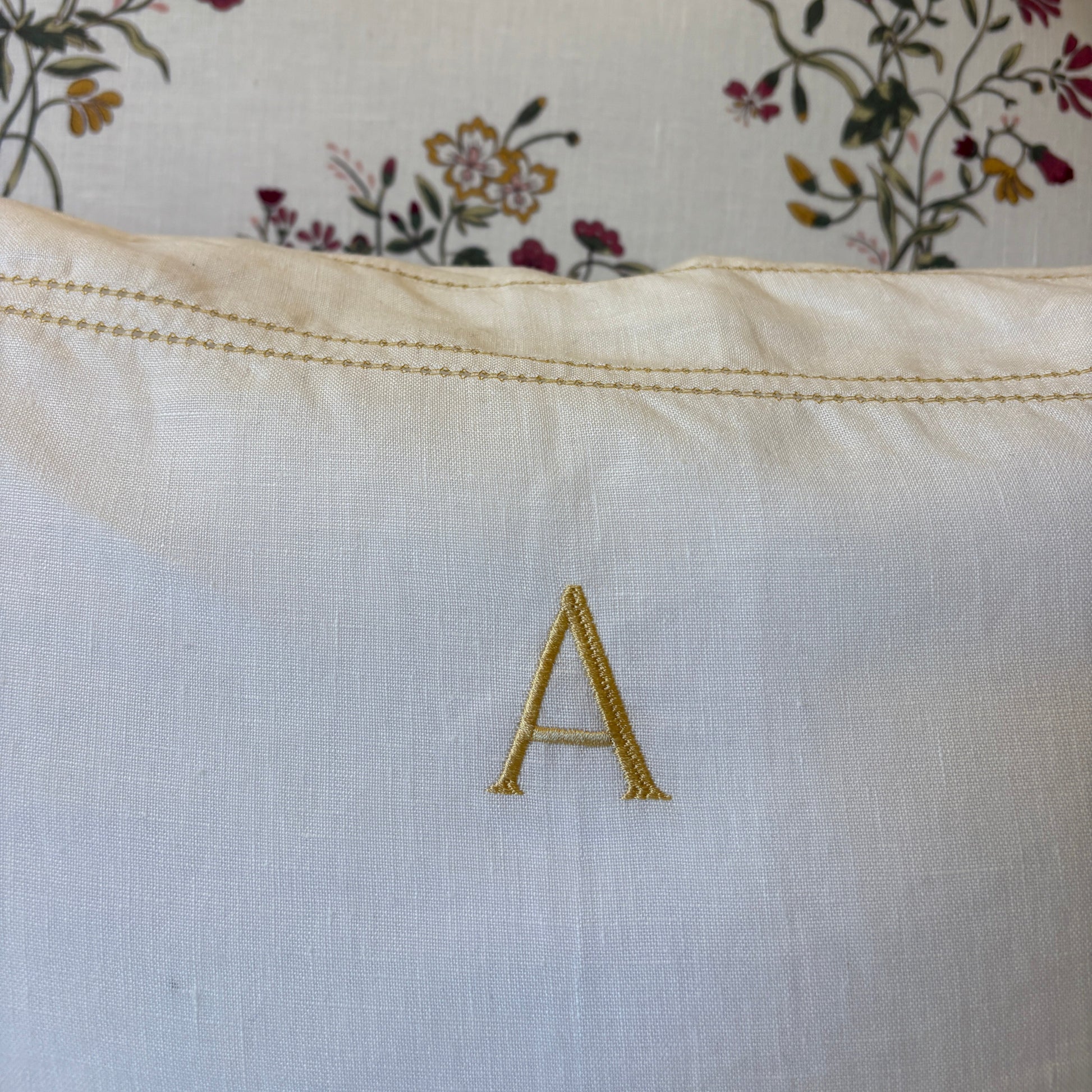 close up of letter A embroidered on ochre hemstitch pillowcase